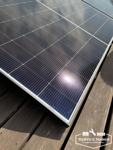 Nahaufnahme von Solarzellen auf einer Holzoberfläche mit reflektierendem Licht.