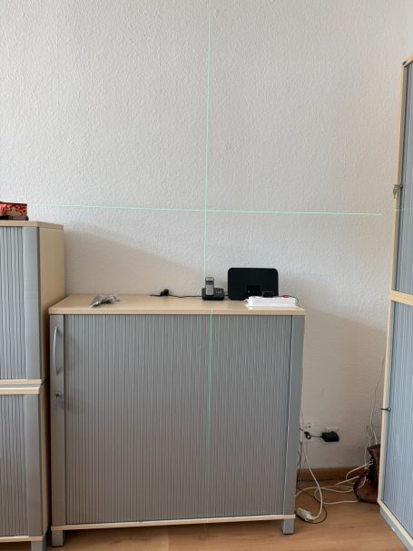 TV-Montage mit Kreuzlinienlaser Exaktes Ausmessen der TV-Wandhalterung mit Kreuzlinienlaser für eine präzise Fernsehermontage in Amberg.